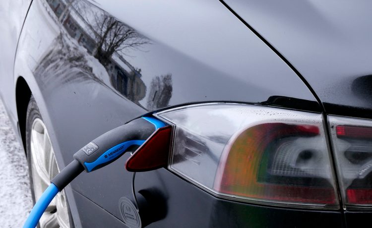 Close-up of an electric vehicle charging cable plugged into a car