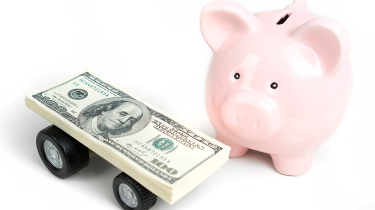 Stack of cash next to a piggy bank