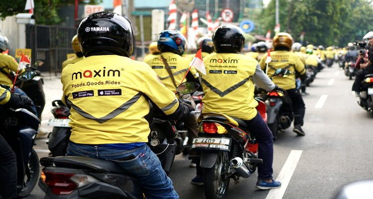 Group of Maxim driver-partners riding motorcycles in yellow jackets