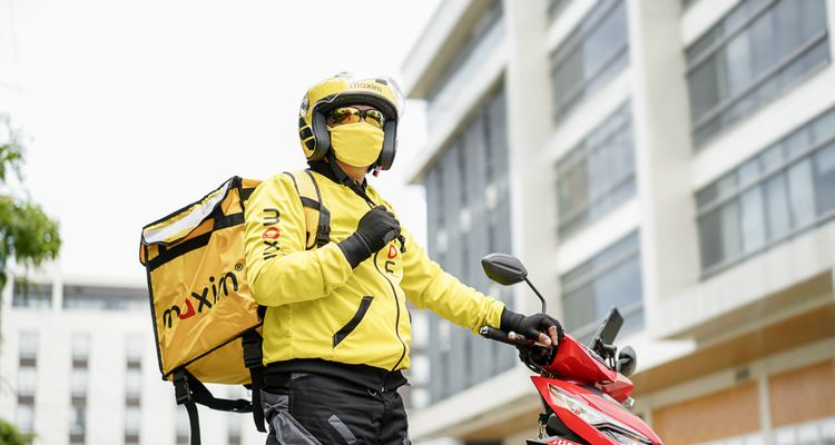Maxim motorcycle courier with a yellow delivery bag