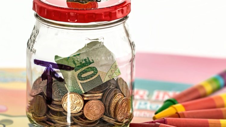 Coins and cash saved in a glass jar